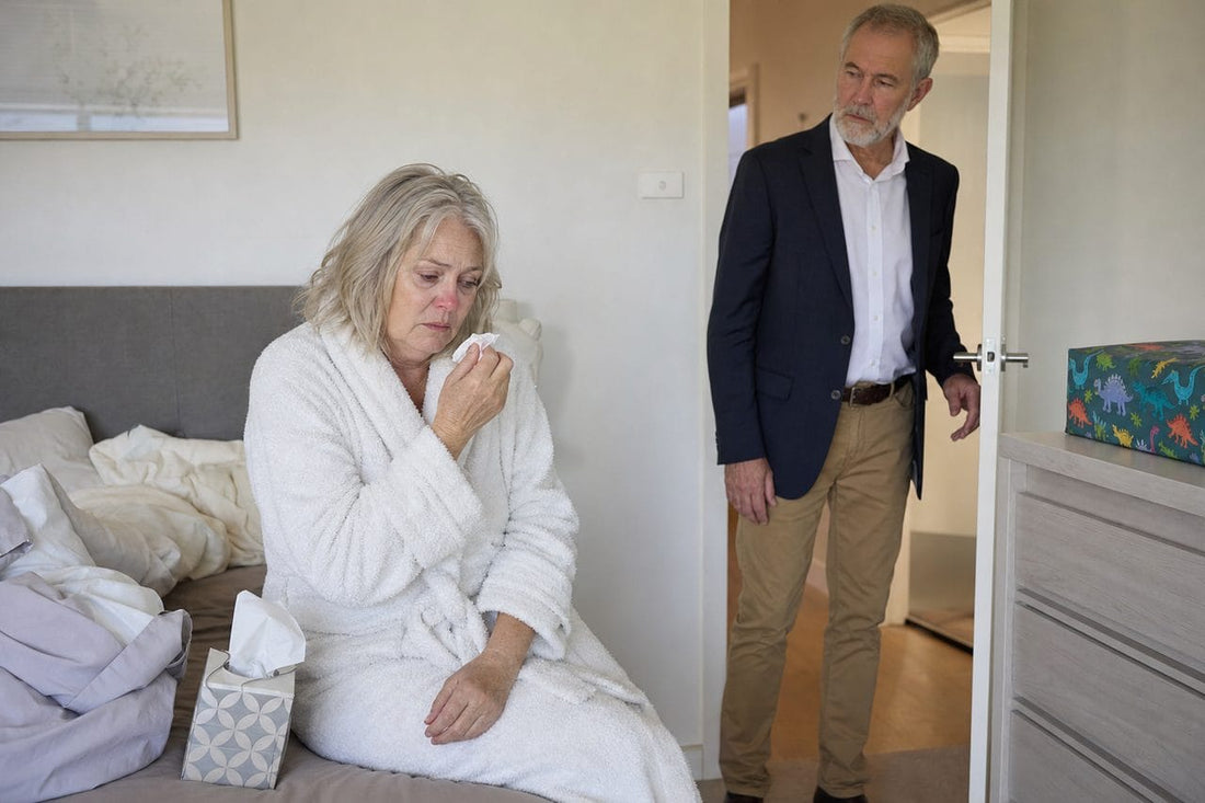 Sarah on the edge of the bed in her dressing gown, blocked and exhausted, as Dan waits in the doorway