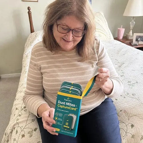Supporting live-page photo of a woman unpacking CaptureCards in a bedroom
