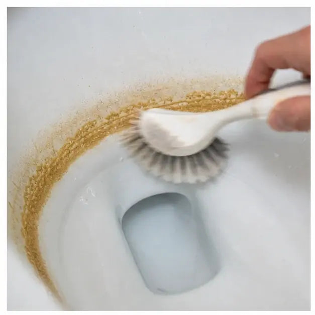 thumbnail — close-up of a toilet waterline with a visible brown / orange ring, hand holding a scrub brush hovering above. Slight motion blur on the brush. Mood: defeated weekly chore.